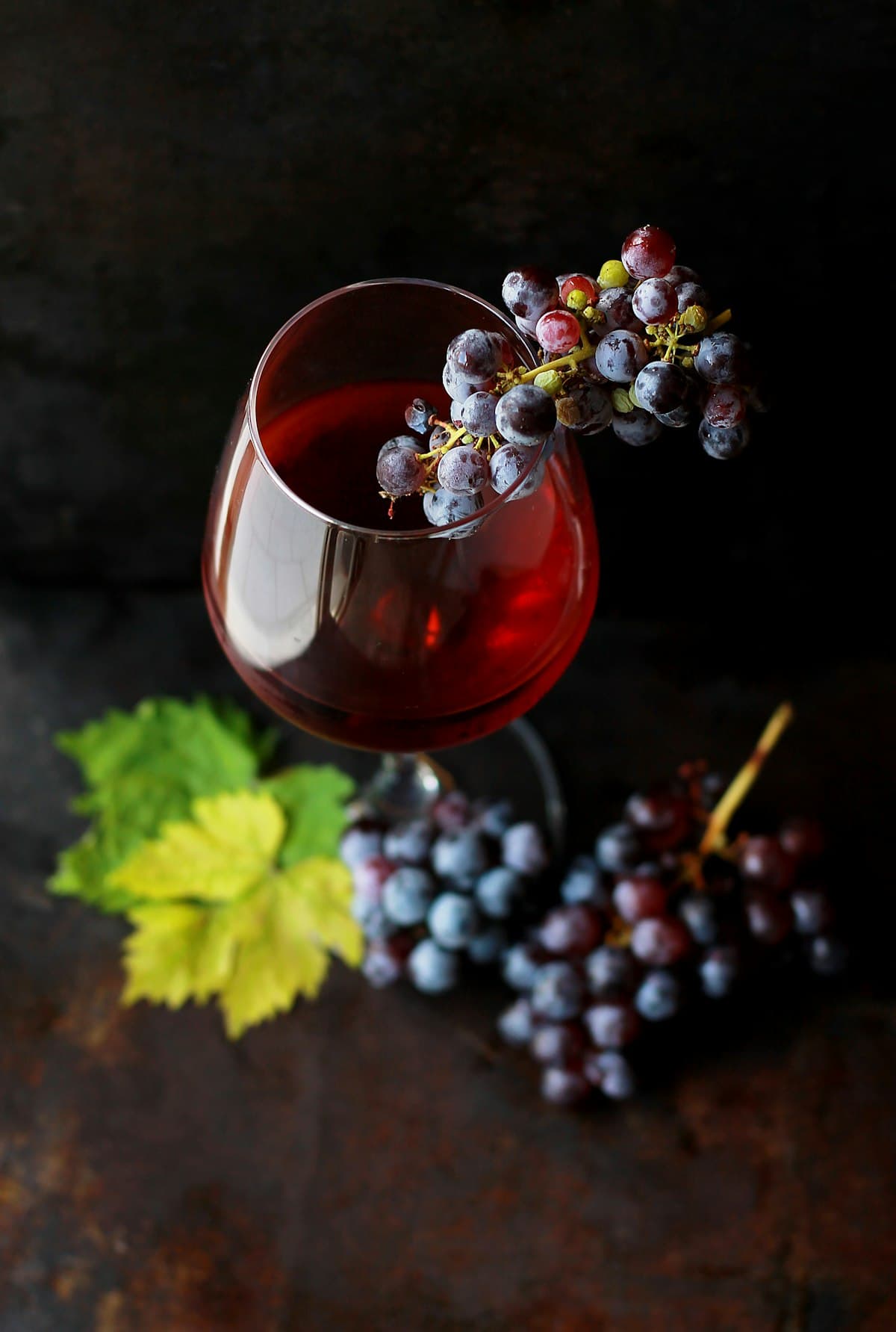 Garrafa de vinho tinto e duas taças sobre mesa de madeira